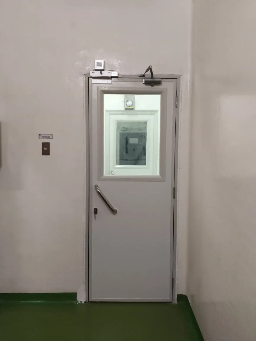 Pintu clean room single swing MKP dengan jendela intip, pull handle stainless, dan door closer